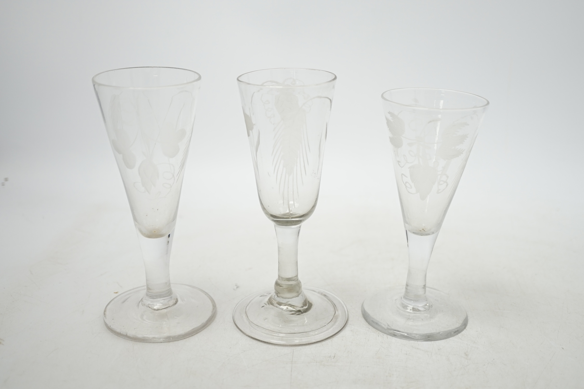 Three mid 18th century engraved ale glasses, all with hop decoration to the bowls, 14cm. Condition - good